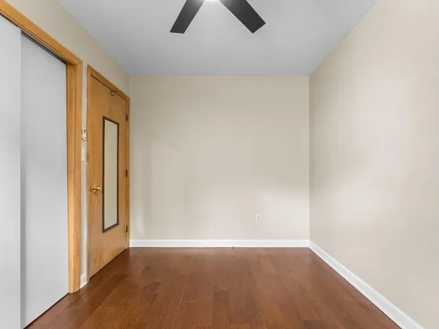 an empty room with closet and chandelier fan