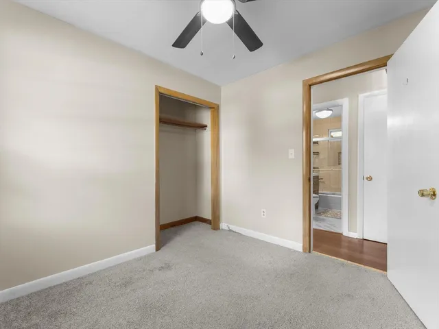 an empty room with closet and a chandelier fan