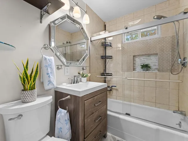 a bathroom with a sink a mirror toilet and bathtub