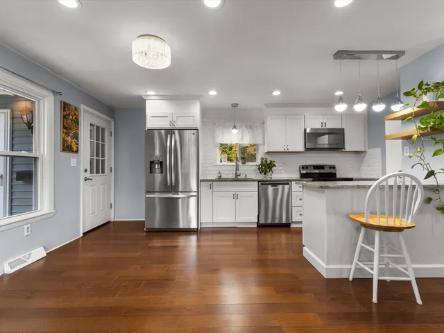 a kitchen with granite countertop a refrigerator and a stove top oven