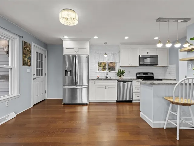 a kitchen with a refrigerator and a stove top oven
