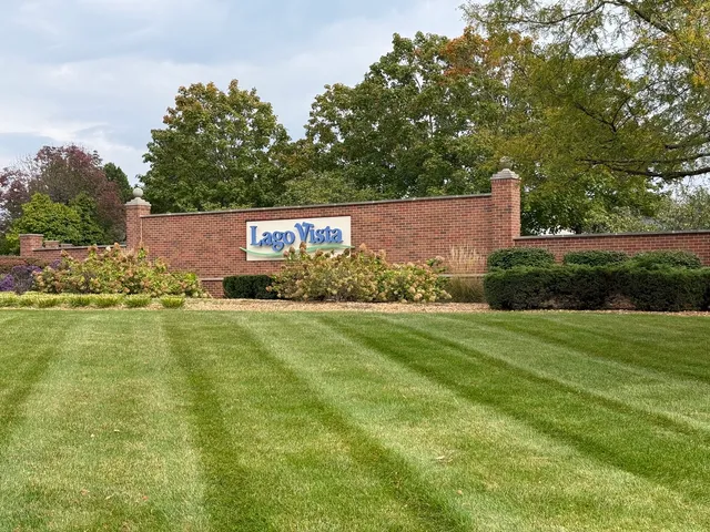 a sign that is sitting in the grass next to a road