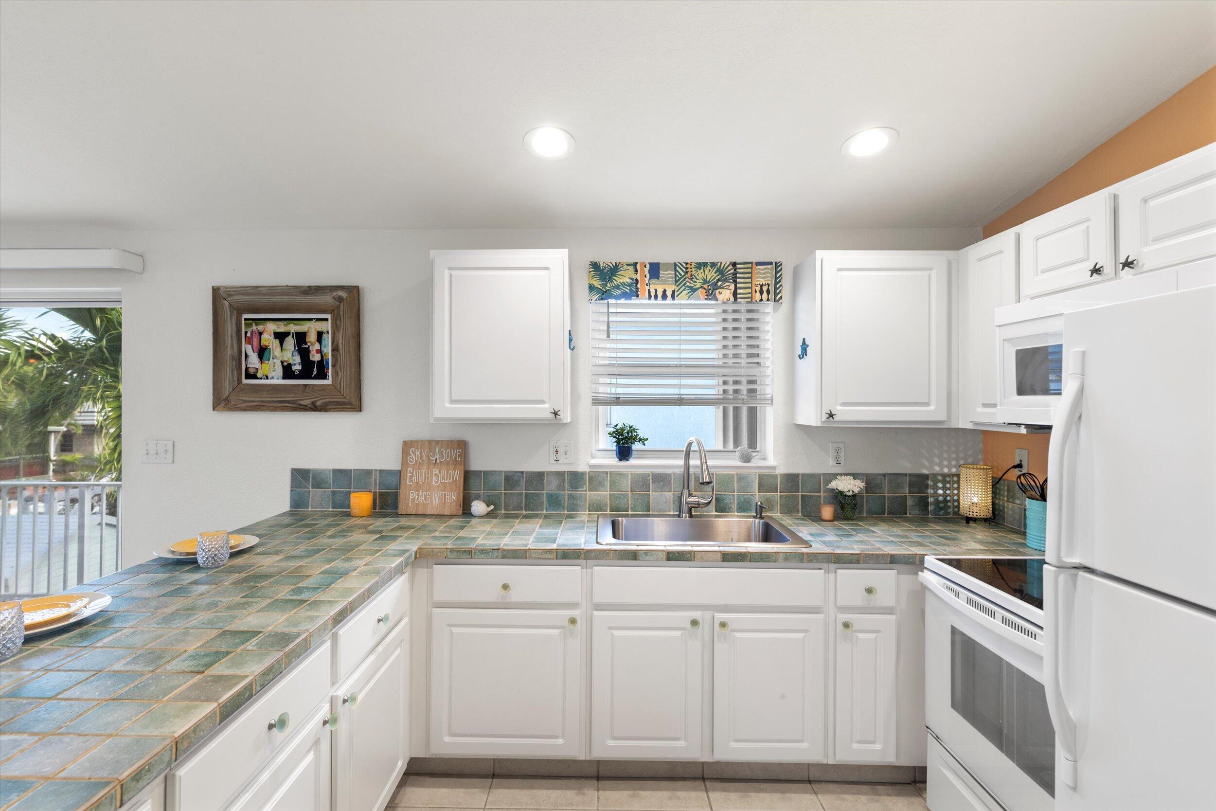 157 Mars Lane Key West, FL 33040 - Photo 18 of 41 a kitchen with granite countertop white cabinets and white appliances
