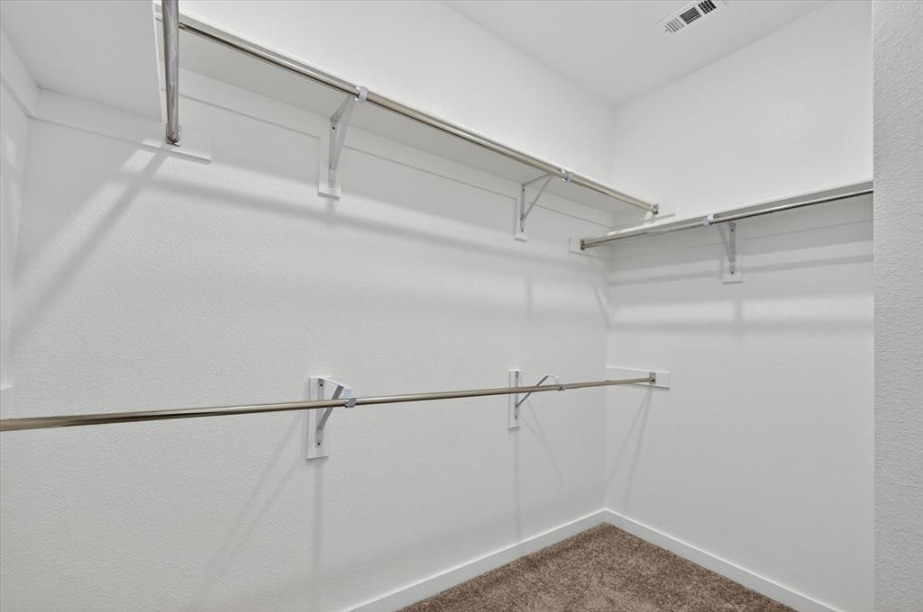 1153 Queensdown Way Forney, TX 75126 - Photo 25 of 26 Walk-in closet featuring white painted walls and shelving