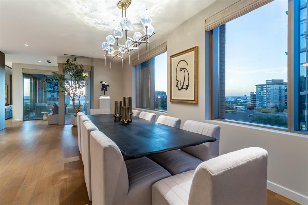 2300 Wolf Street, Unit 7D Dallas, TX 75201 - Photo 11 of 40 a view of a dining room with furniture a chandelier and wooden floor
