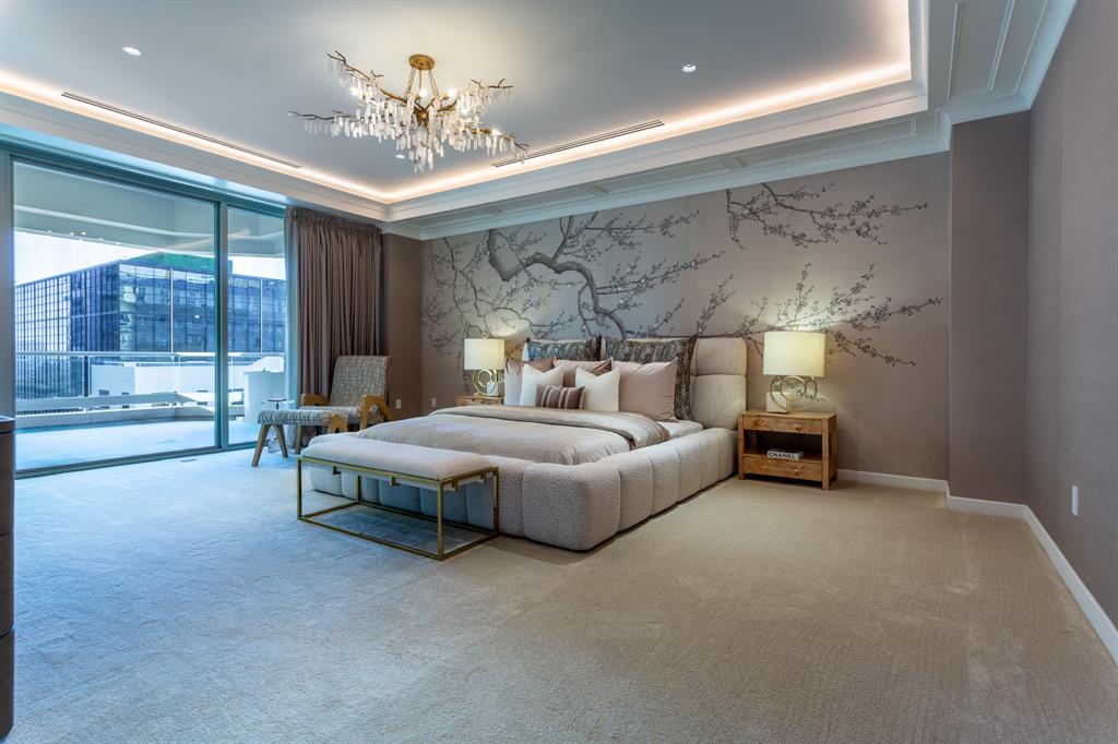 2300 Wolf Street, Unit 7D Dallas, TX 75201 - Photo 24 of 40 a spacious bedroom with a bed and a chandelier