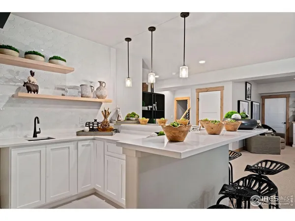 a living room with furniture a table and kitchen view