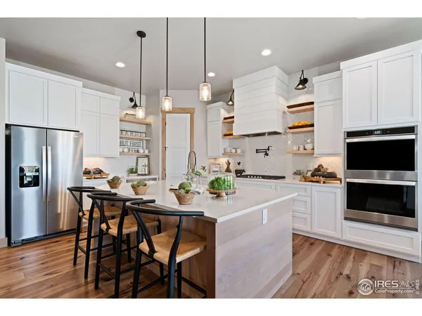 a kitchen with a table chairs refrigerator and microwave