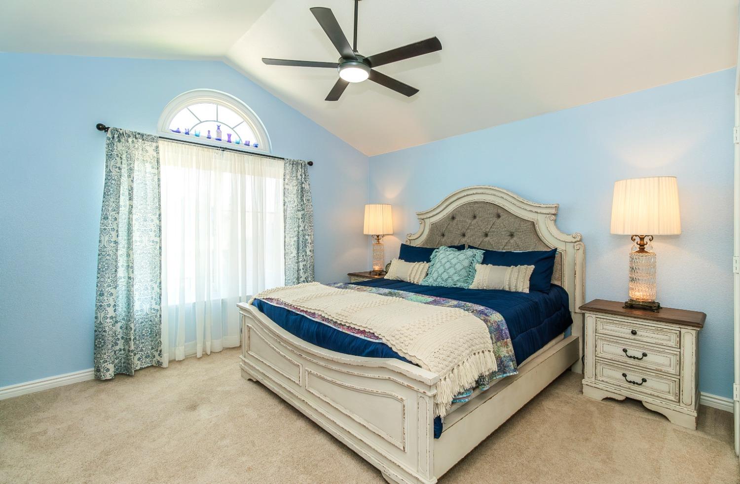 1323 Oak Avenue Clovis, CA 93611 - Photo 18 of 42 a bedroom with a bed a chandelier and a window