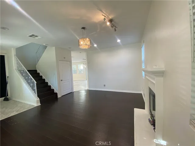 an empty room with wooden floor and staircase