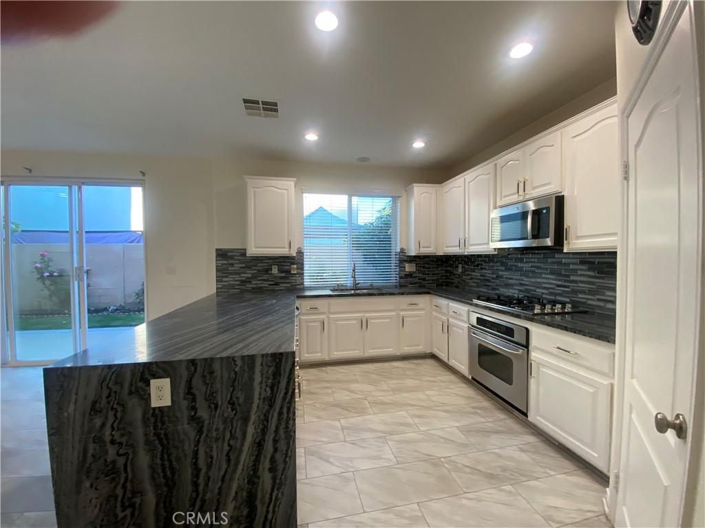 19303 Cohasset Street Reseda, CA 91335 - Photo 8 of 30 a large kitchen with stainless steel appliances granite countertop a stove a sink and a microwave