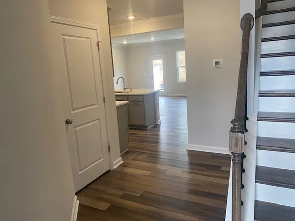 a view of a hallway with wooden floor and staircase