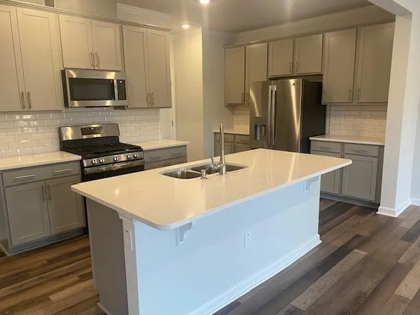 a kitchen with stainless steel appliances a refrigerator sink and microwave