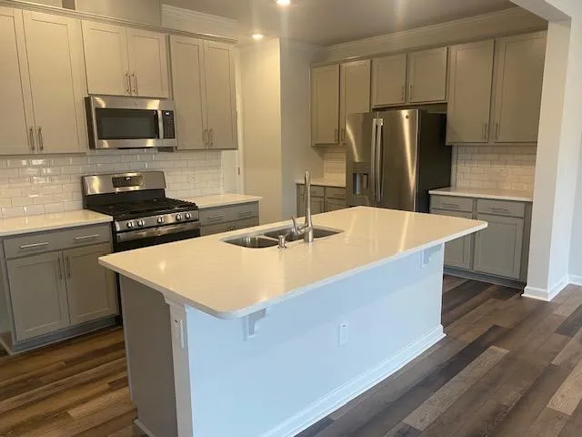 a kitchen with stainless steel appliances a refrigerator sink and microwave