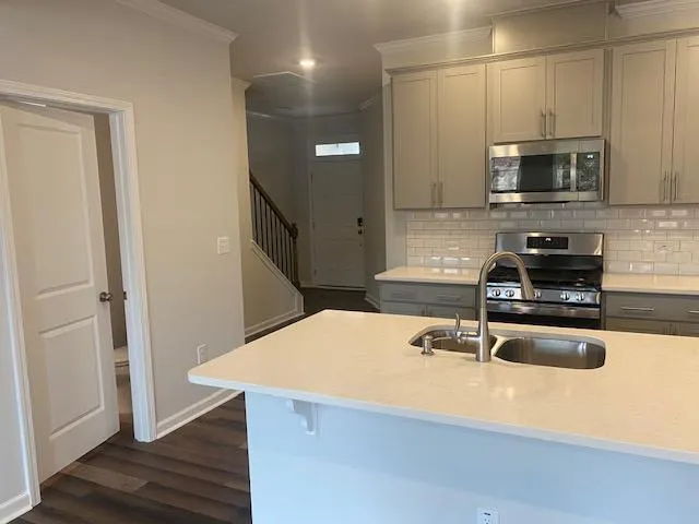 a kitchen with a sink a microwave and cabinets