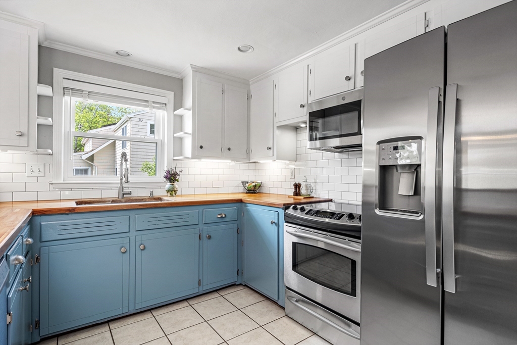 21 Linscott Road Hingham, MA 02043 - Photo 22 of 32 a kitchen with white cabinets and stainless steel appliances