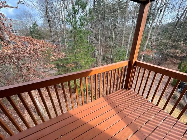 a view of balcony with wooden floor and fence