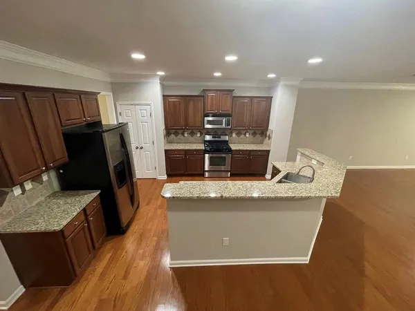 a view of a kitchen with kitchen island a counter top space appliances and a ceiling fan