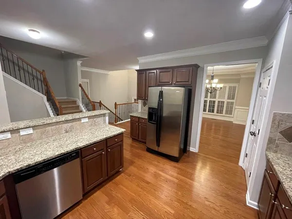 a kitchen with granite countertop a refrigerator and a sink
