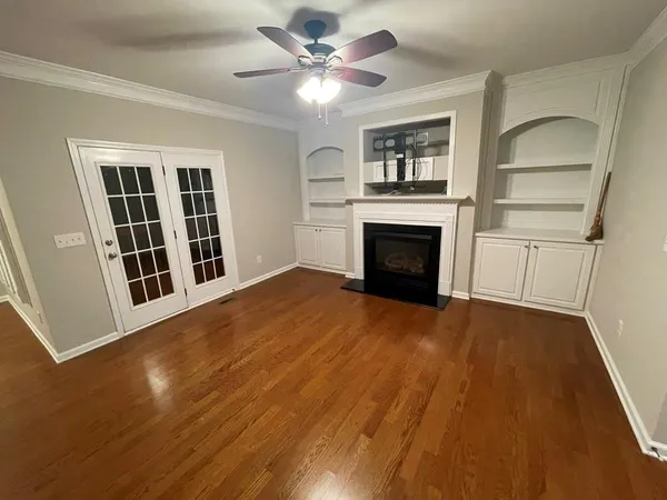 a view of an empty room with a fireplace and a window