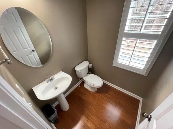 a bathroom with a toilet sink mirror and vanity