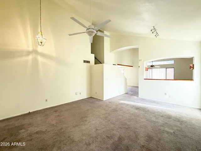 en empty room with an entryway and a chandelier