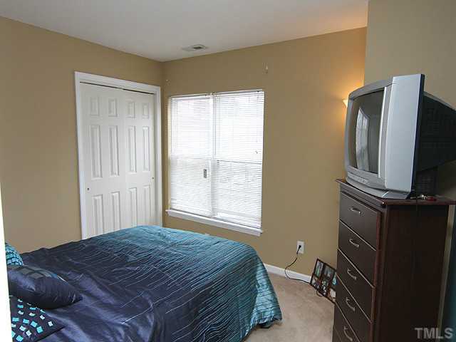 429 Hay River Street Garner, NC 27529 - Photo 9 of 12 a bedroom with a bed closet and flat tv screen