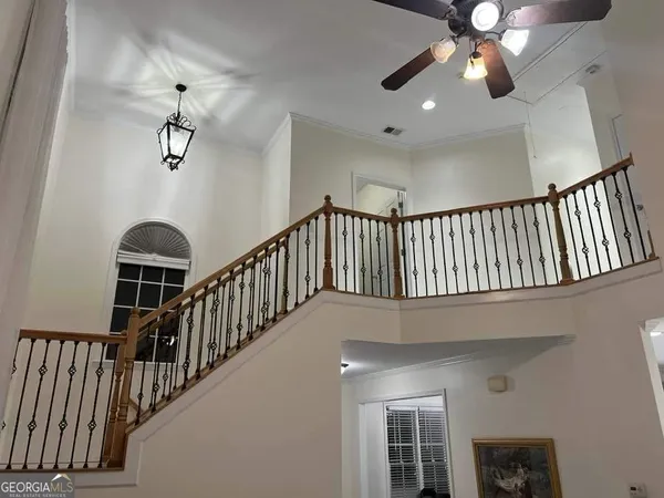 a view of staircase with railing and a chandelier