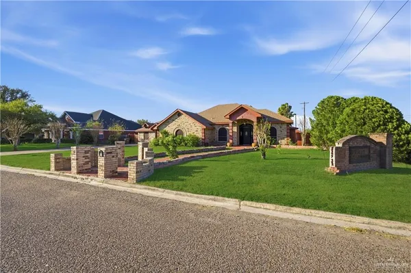 a view of a house with a big yard and large trees