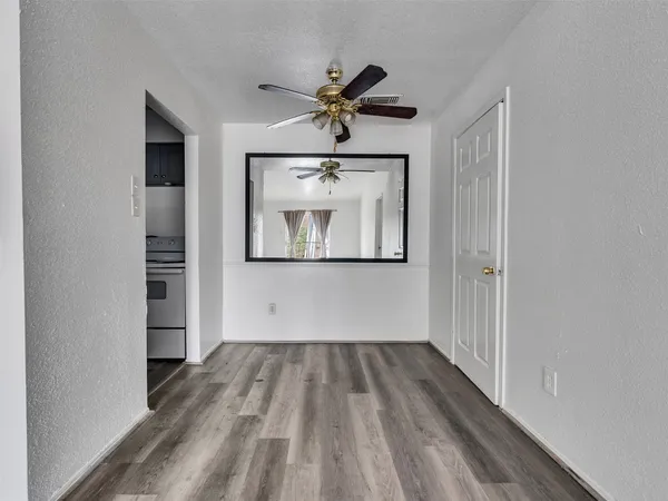 a view of empty room with wooden floor and window
