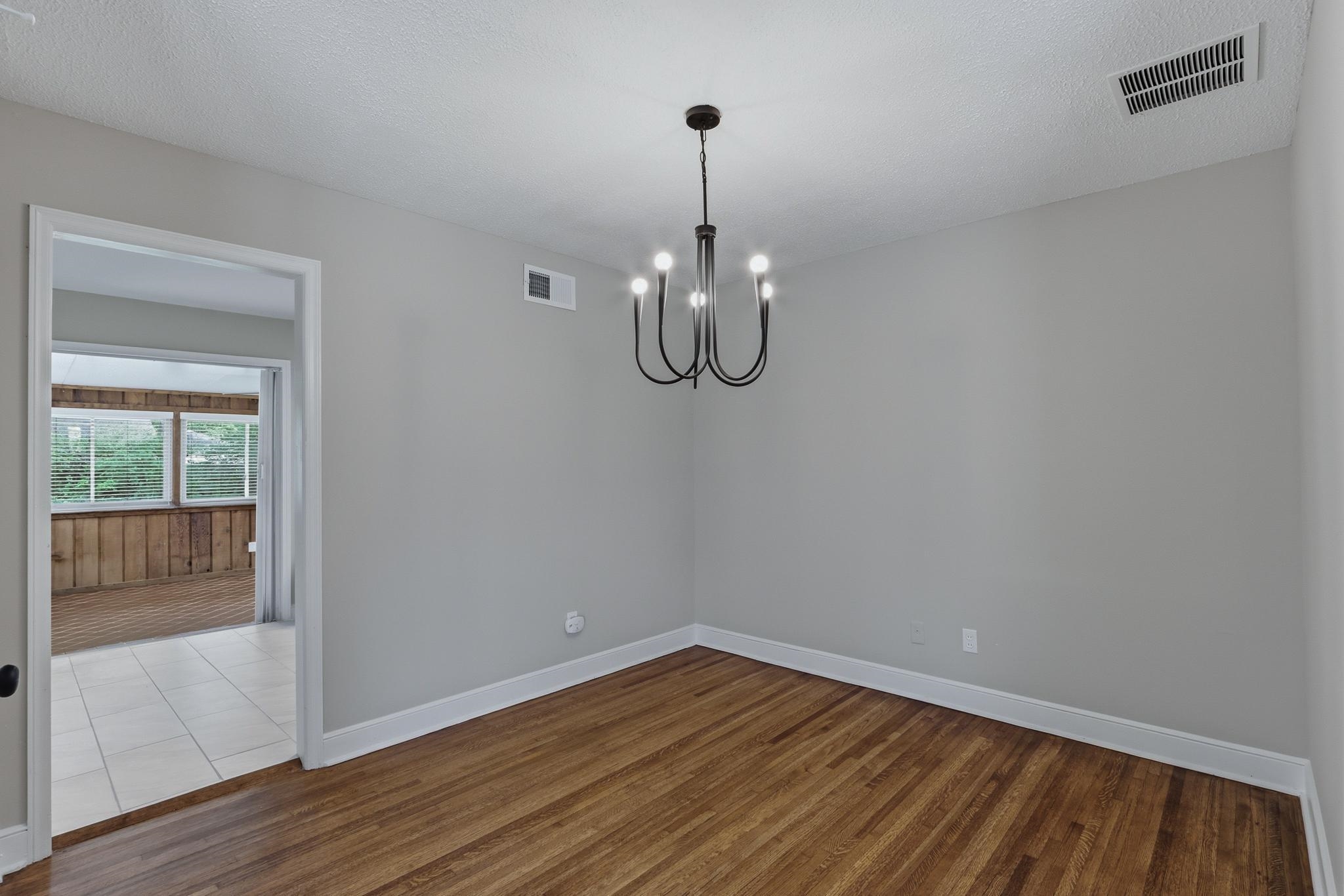 312 Fernway Road Memphis, TN 38117 - Photo 13 of 38 Spare room with wood finished floors, suspended lighting, and a textured ceiling