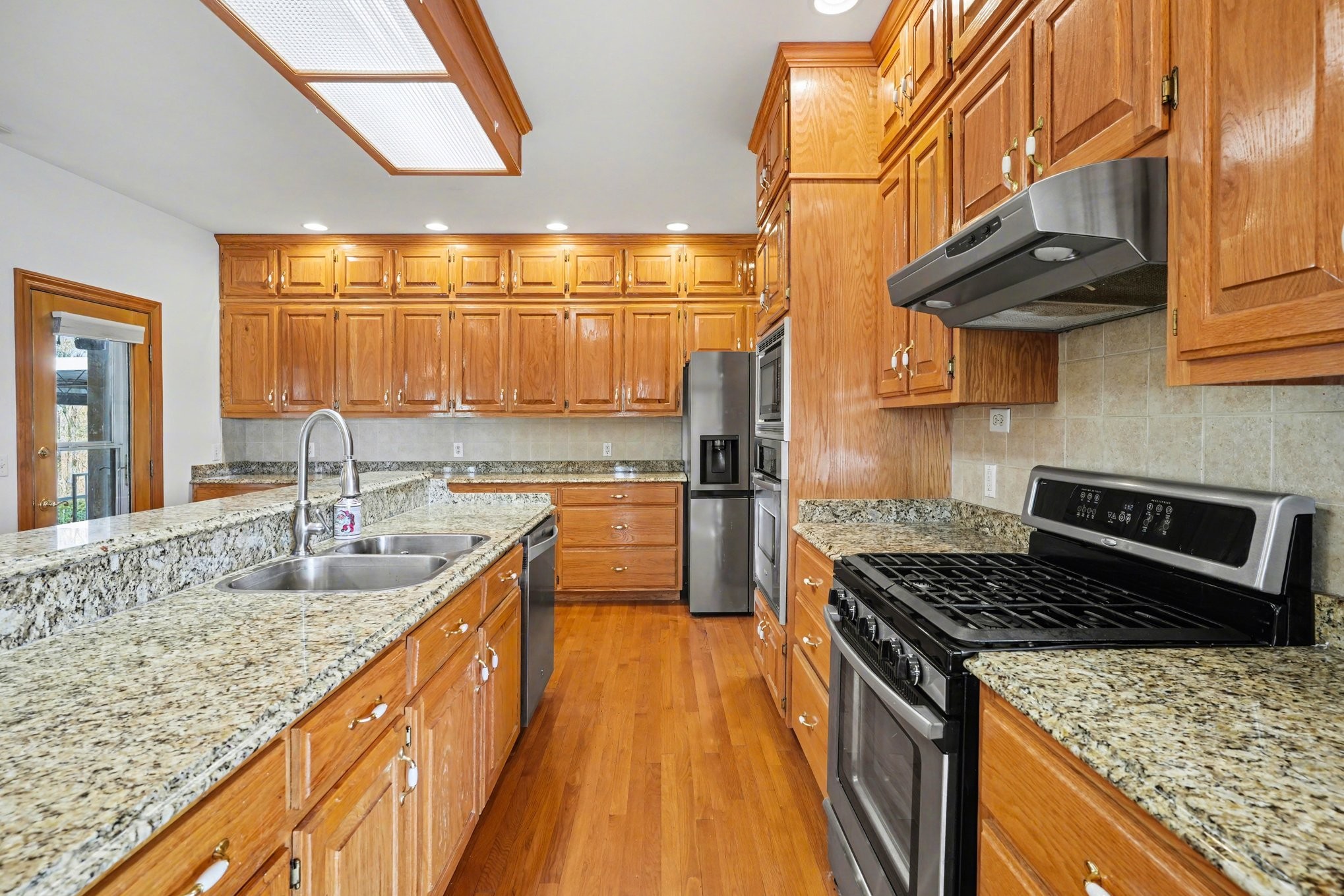 11948 Betts Road Greenbrier, TN 37073 - Photo 12 of 44 a kitchen with granite countertop a sink a counter top space and stainless steel appliances