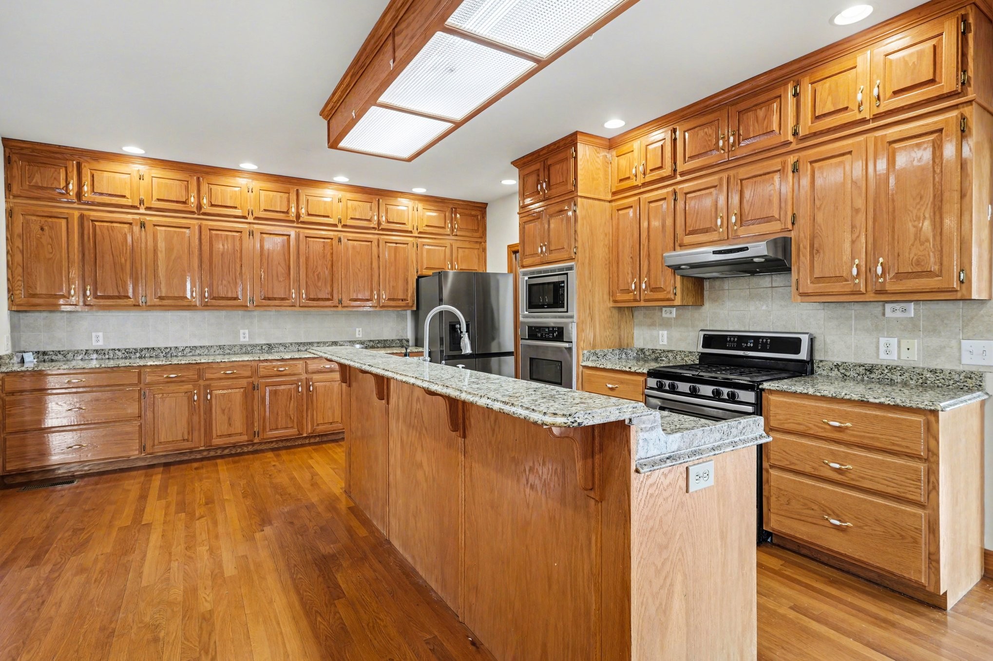 11948 Betts Road Greenbrier, TN 37073 - Photo 10 of 44 a kitchen with stainless steel appliances granite countertop a stove a sink and a microwave