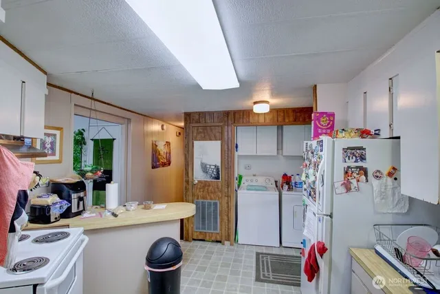 a kitchen with a refrigerator and a stove top oven