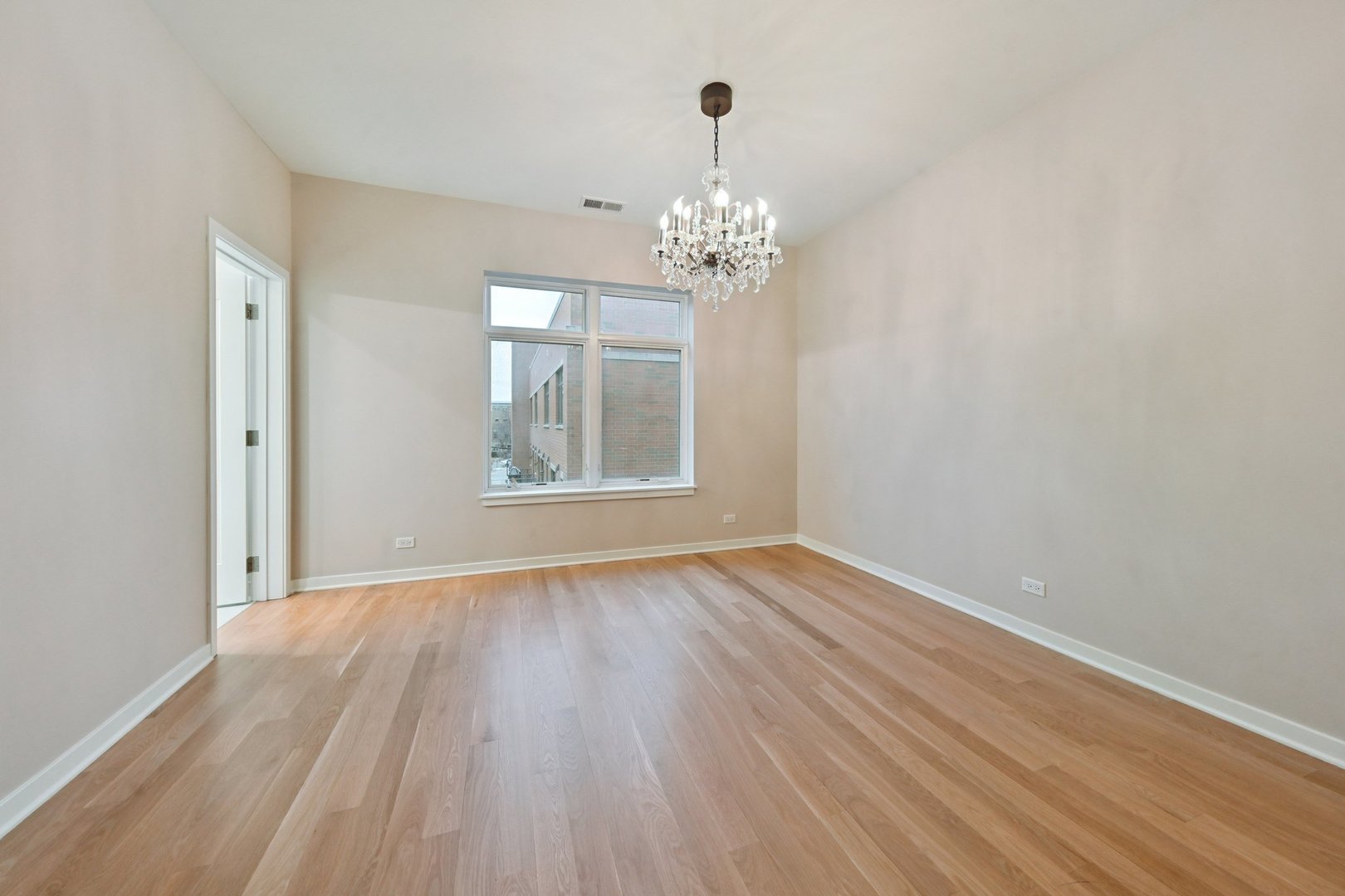 1640 South Prairie Avenue Chicago, IL 60616 - Photo 16 of 34 a view of an empty room with wooden floor and a window