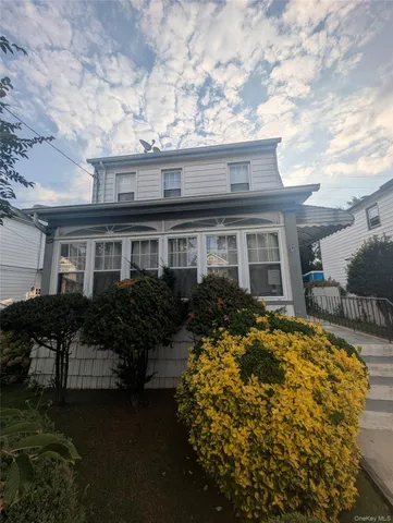 a front view of house with yard and trees around