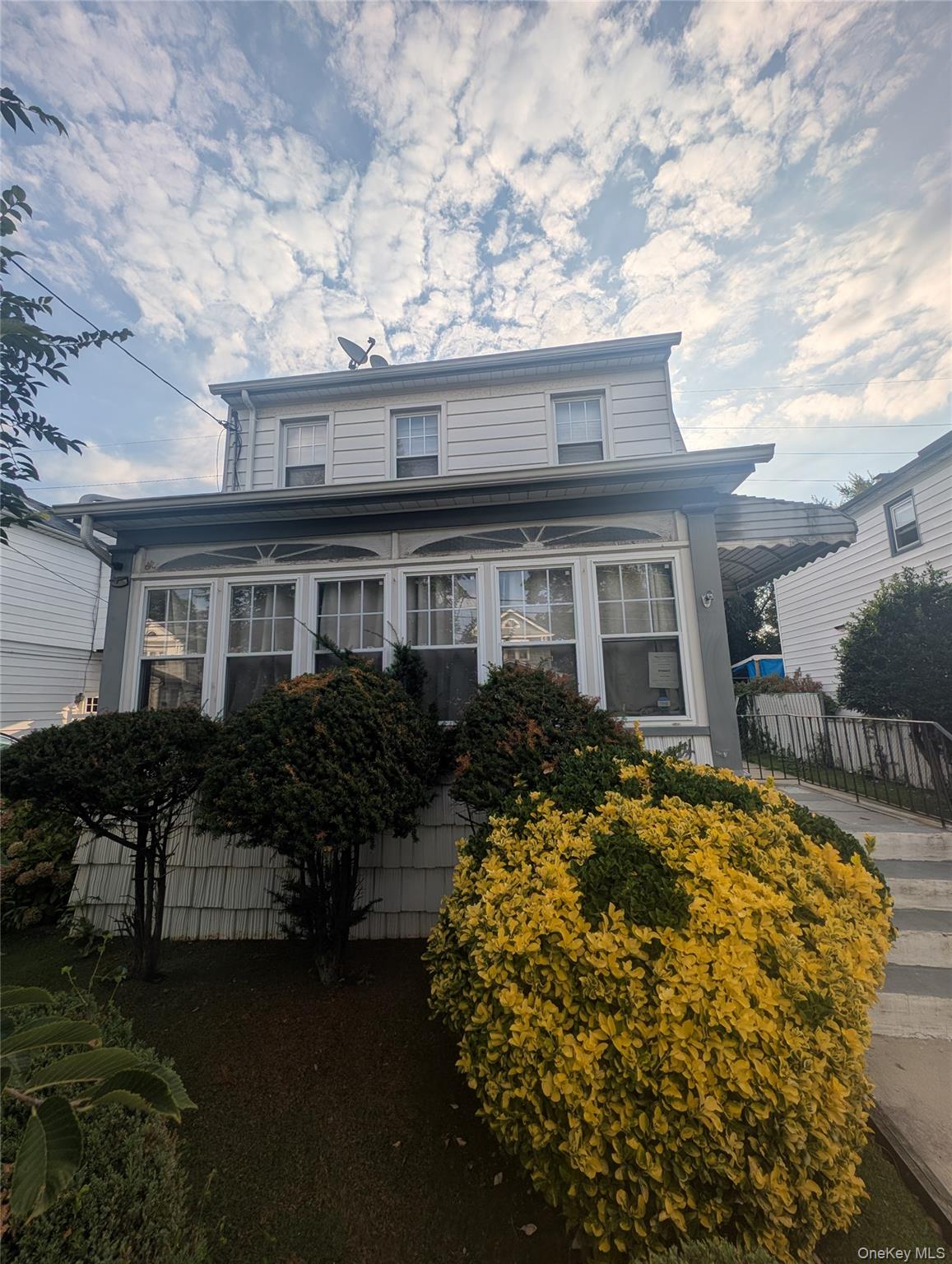 a front view of house with yard and trees around