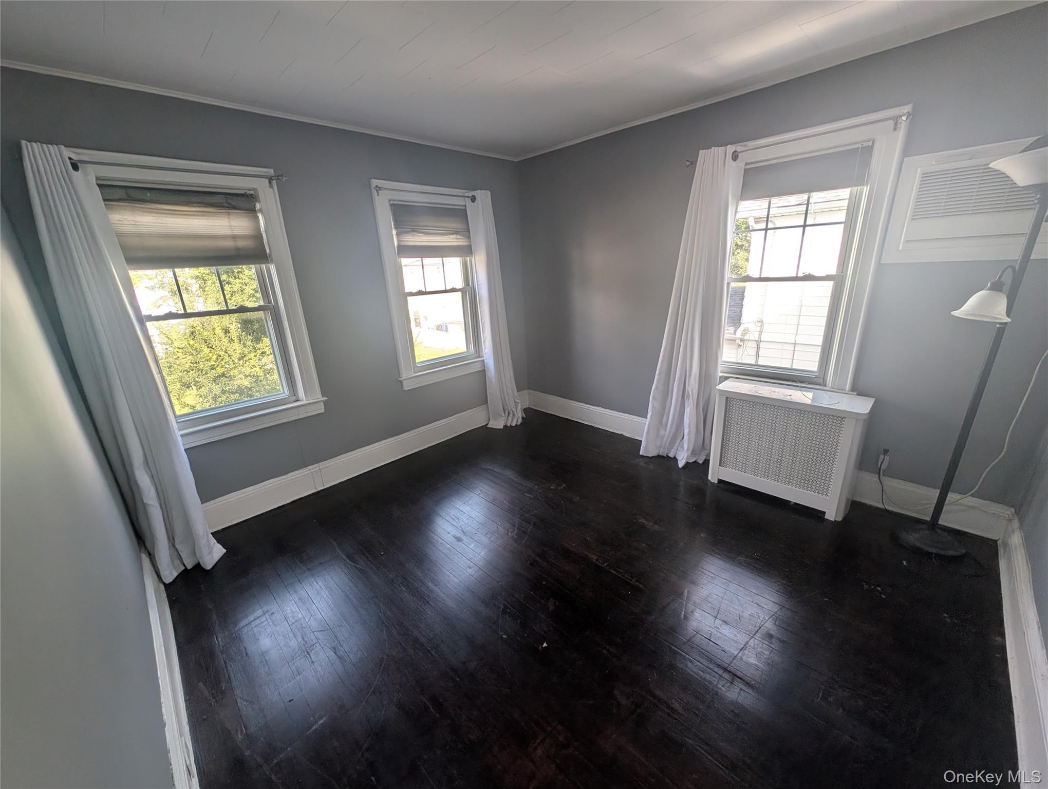 81 Cochran Place Valley Stream, NY 11581 - Photo 6 of 12 an empty room with wooden floor and windows