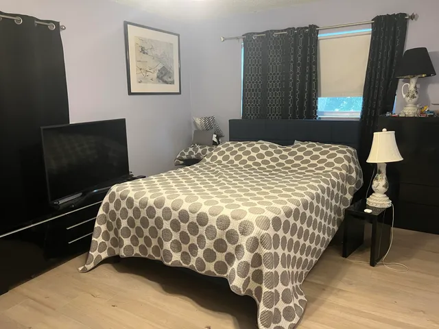 a bedroom with a bed and painting on the wall