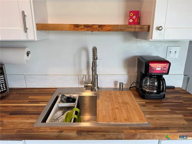 a kitchen with a stove and a wooden floor