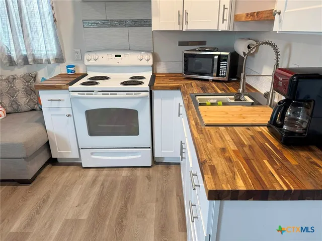 a kitchen with granite countertop a stove and a wooden floor
