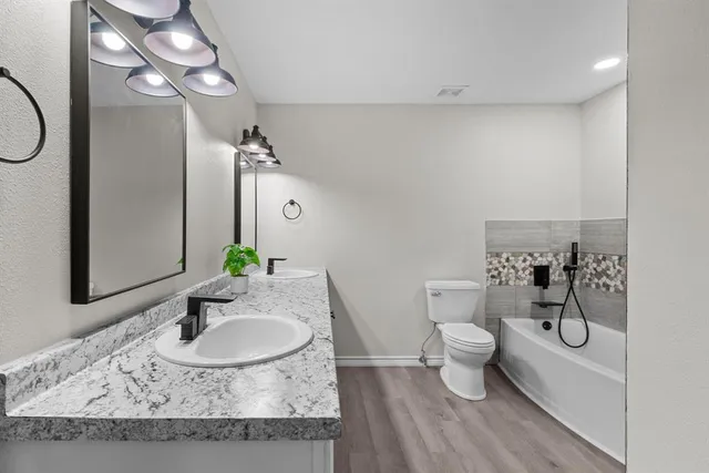 a bathroom with a granite countertop sink a toilet and a mirror