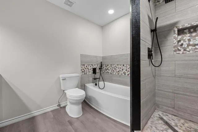 a bathroom with a toilet and a shower