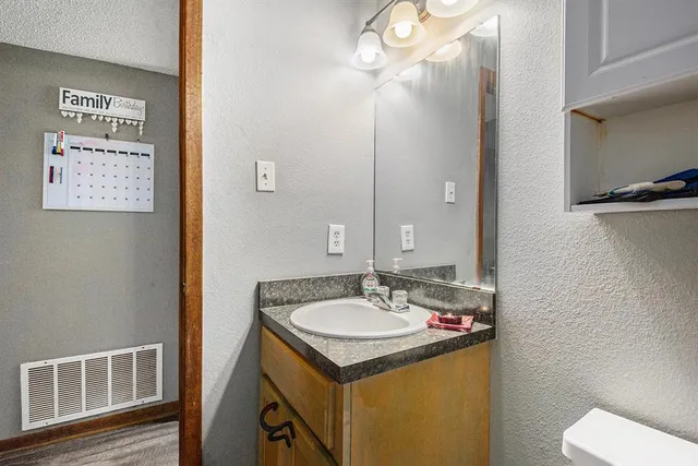 a bathroom with a sink toilet and a mirror