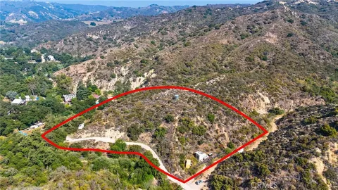 an aerial view of residential house with yard and mountain view in back