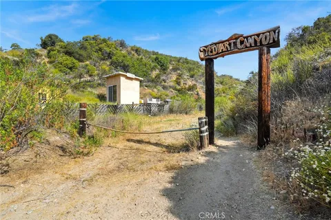 a view of swimming pool of water with lawn chairs and large trees