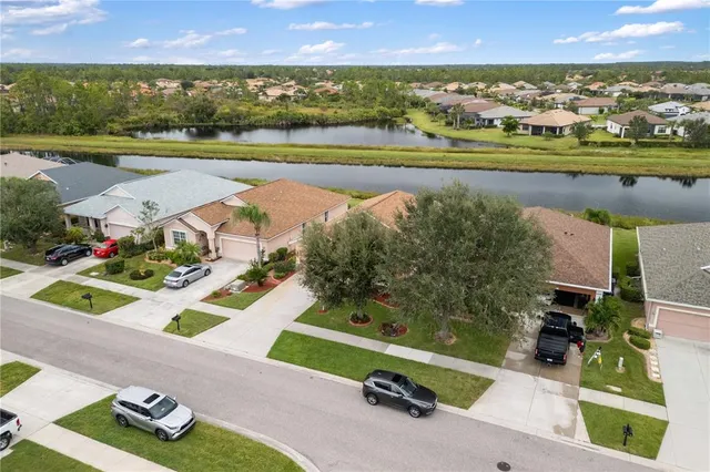 an aerial view of a residential houses with outdoor space and lake view