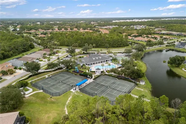 an aerial view of residential houses with outdoor space and lake view