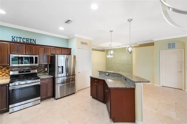 a kitchen with granite countertop a refrigerator and a sink