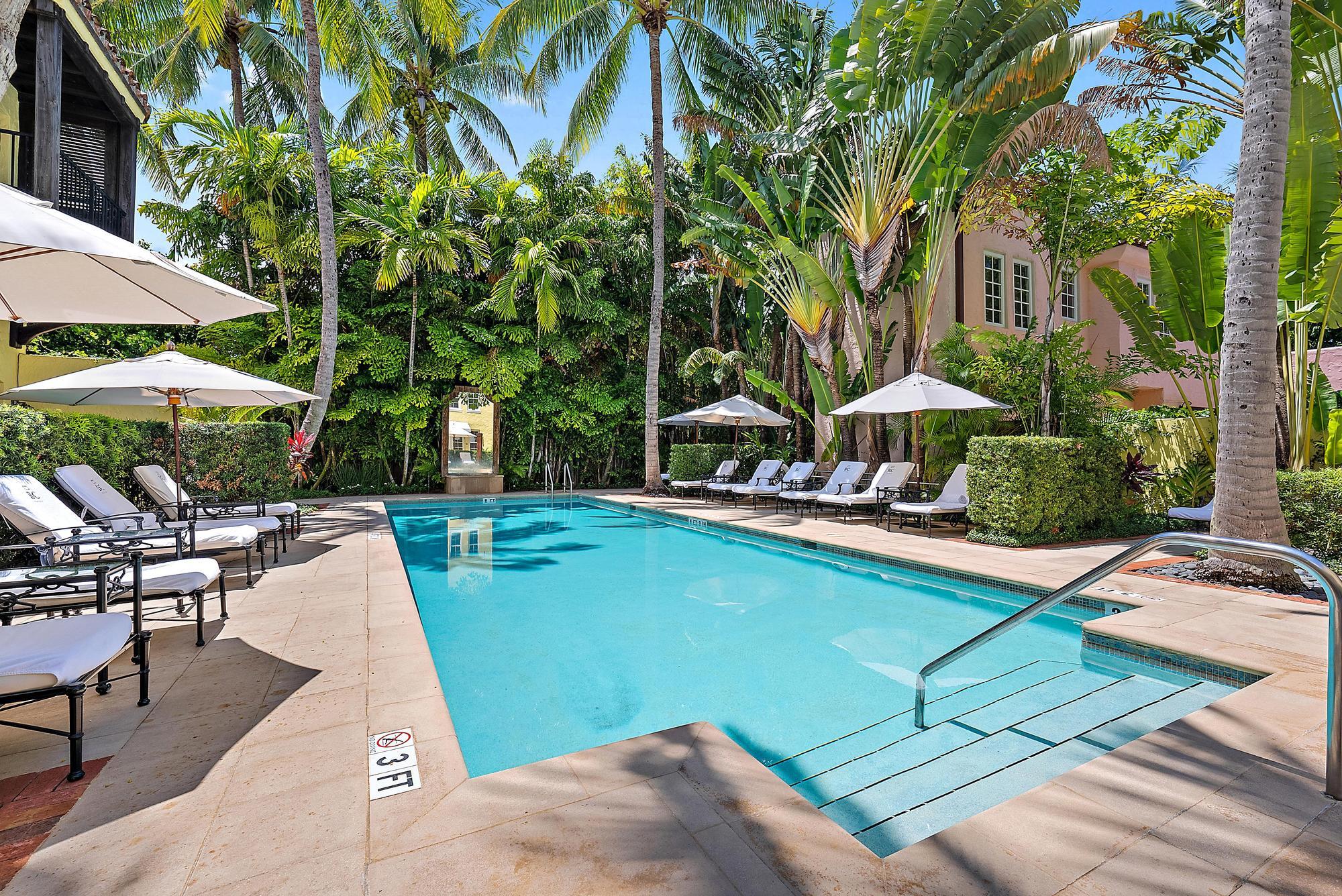 301 Australian Avenue, Unit 305 Palm Beach, FL 33480 - Photo 13 of 19 a view of a swimming pool with lawn chairs under an umbrella